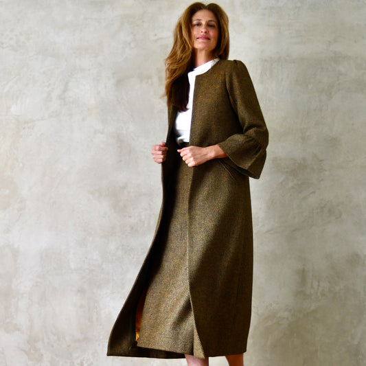 Bespoke Bell Sleeve A-Line Coat in Green and Orange Patterned Tweed. A longer length A-Line coat in a wonderfully elegant patterned tweed with shoulder and sleeve cuff details. Perfect for winter racing. Entirely made in Great Britain. Shown as a tweed suit.