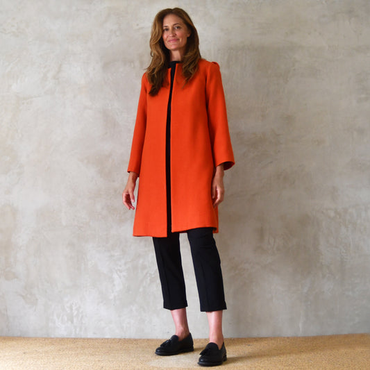 Bespoke Shoulder Detail Trapeze Coat in Burnt Orange Wool Crepe. An elegant alternative to a jacket, our mid length trapeze coat will take you to town, work, country and back. Handmade in Great Britain. Front Shot