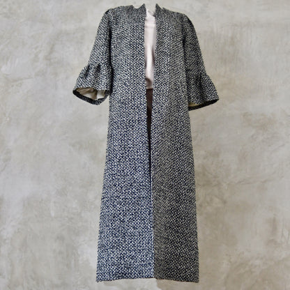 A Longer length Bell Sleeve A-Line Coat in Black and OffWhite Linton Tweeds Boucle
This is an elegant longer length A-Line coat in a patterned boucle from Carlisle. With a magnificent drape and delicate sleeve and shoulder detailing, this coat will take you everywhere. Handmade in Britain. Front View.